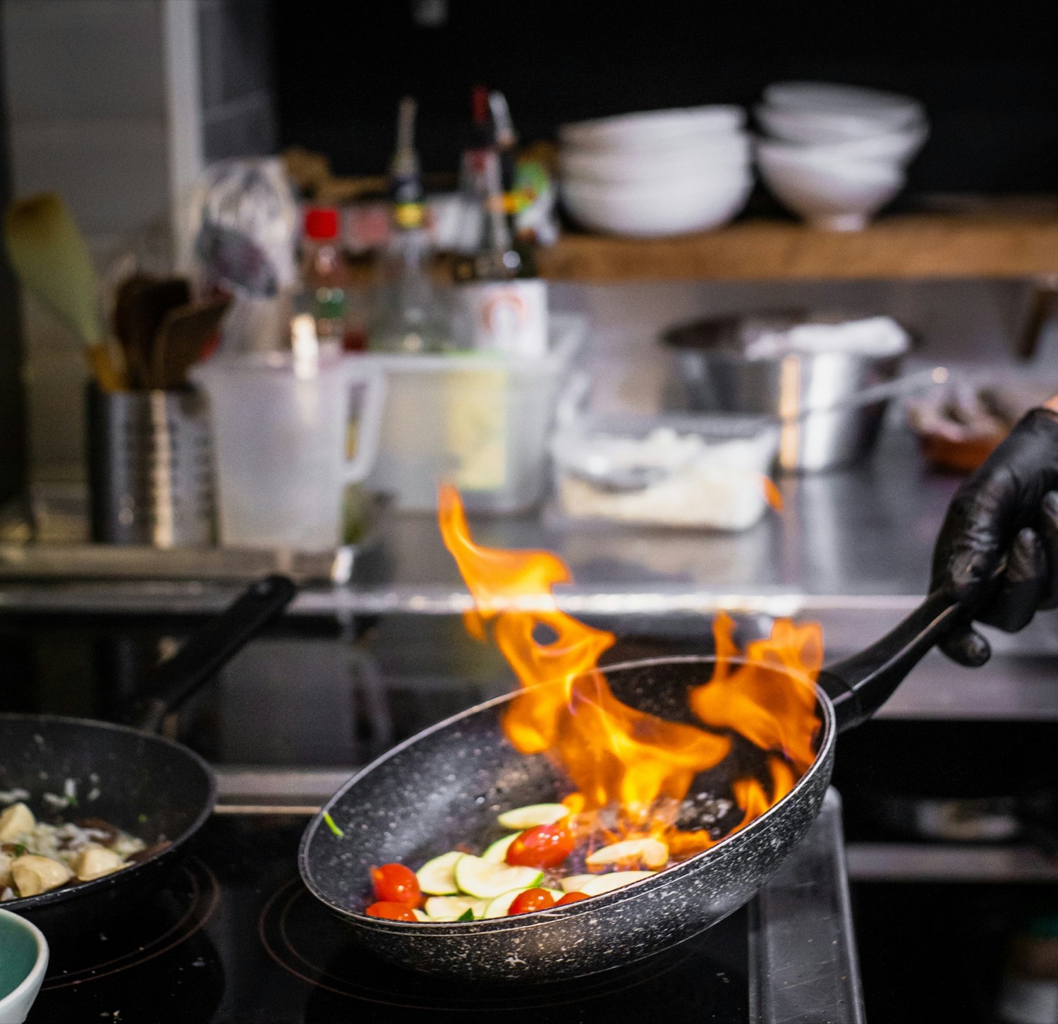 A pan flaring over a restaurant stove